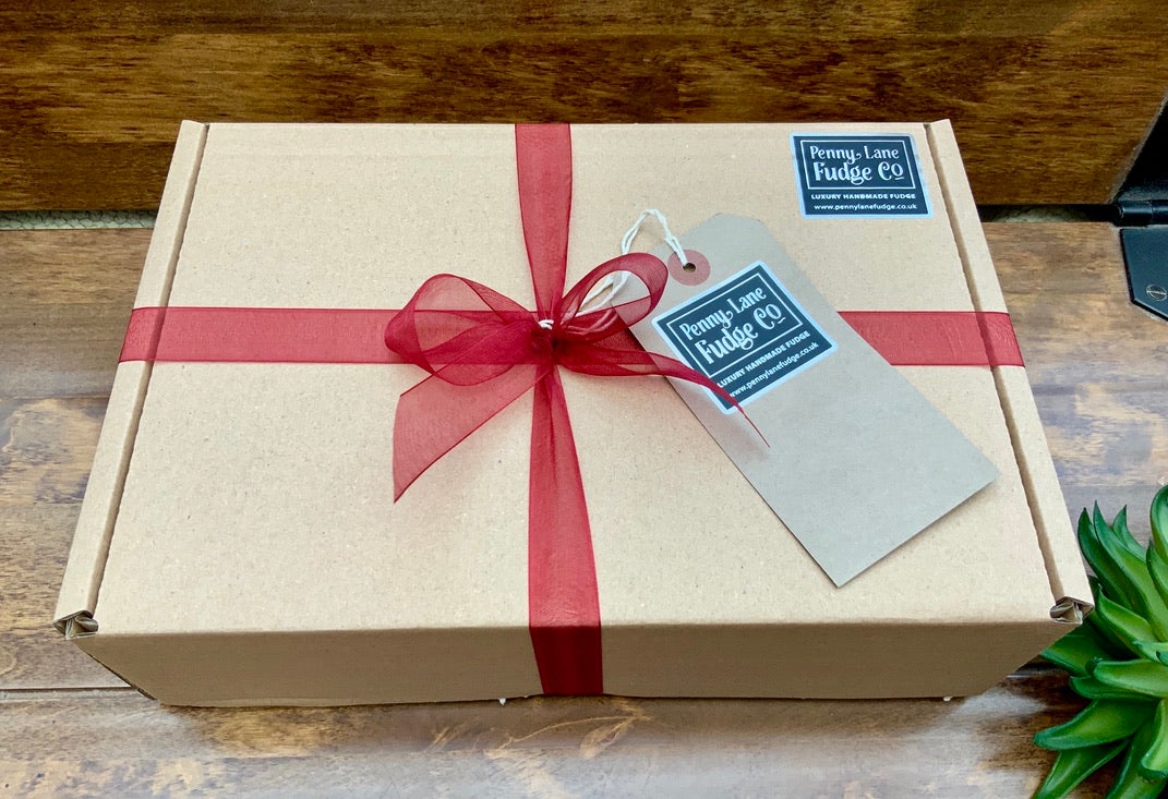 Gift box with a burgundy ribbon and tag on a wooden surface