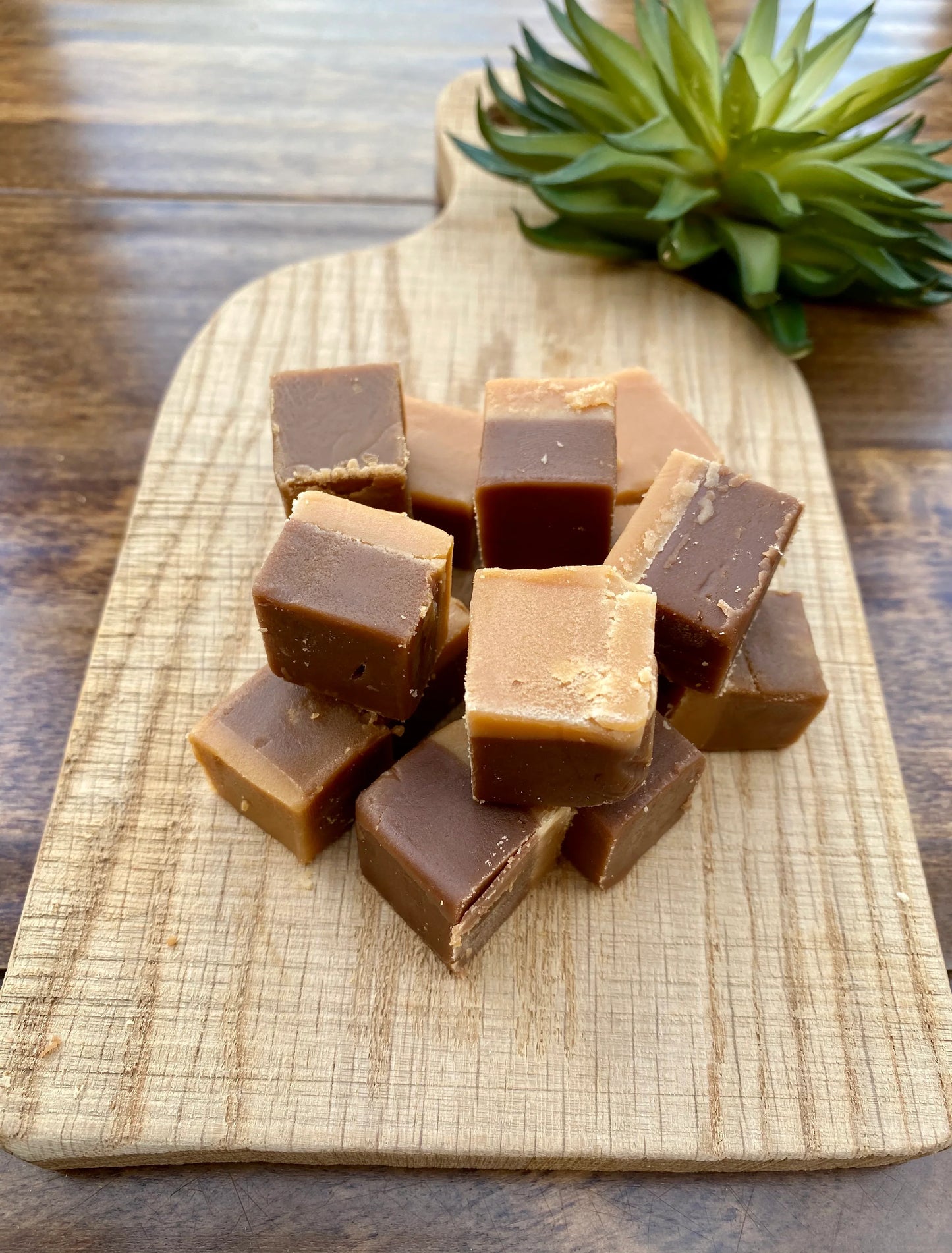Cubes of millionaire fudge on a wooden board.