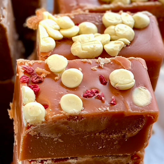 Close-up of a piece of Raspberry fudge with white chocolate chips and red berries.