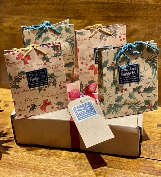 Small gift bags with festive designs and tags on a wooden surface