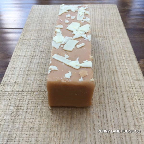Block of fudge with white chocolate pieces on a textured surface, branded 'Penny Lane Fudge Co'.