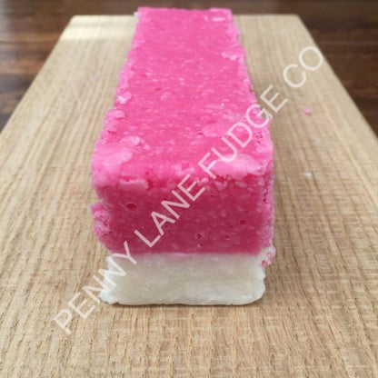 Pink and white layered coconut ice with 'Penny Lane Fudge Co' branding on a wooden surface