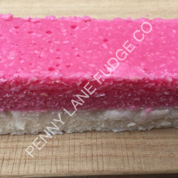 Pink and white layered coconut ice with 'Penny Lane Fudge Co' branding on a wooden surface