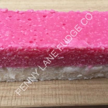 Pink and white layered coconut ice with 'Penny Lane Fudge Co' branding on a wooden surface
