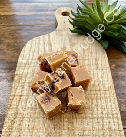 Run & Raisin Fudge on a wooden cutting board, with 'Penny Lane Fudge Co.' branding.
