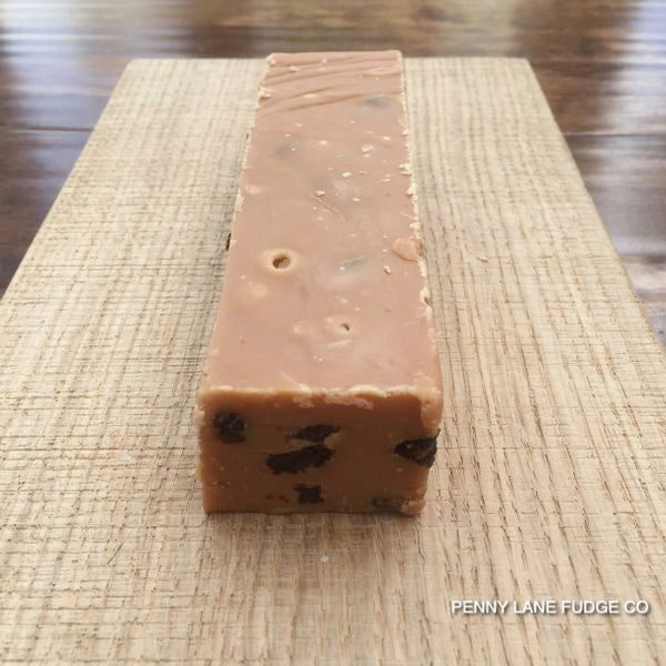 Block of fudge with Rum & raisins on a textured surface, branded 'Penny Lane Fudge Co'.