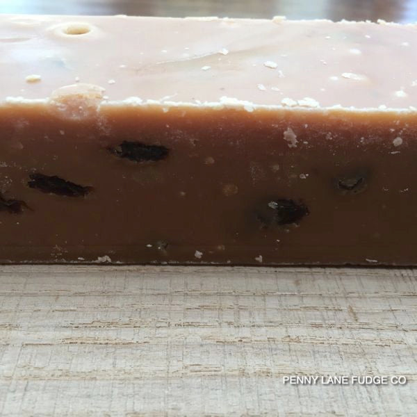 Block of fudge with rum & raisins on a textured surface, branded 'Penny Lane Fudge Co'.