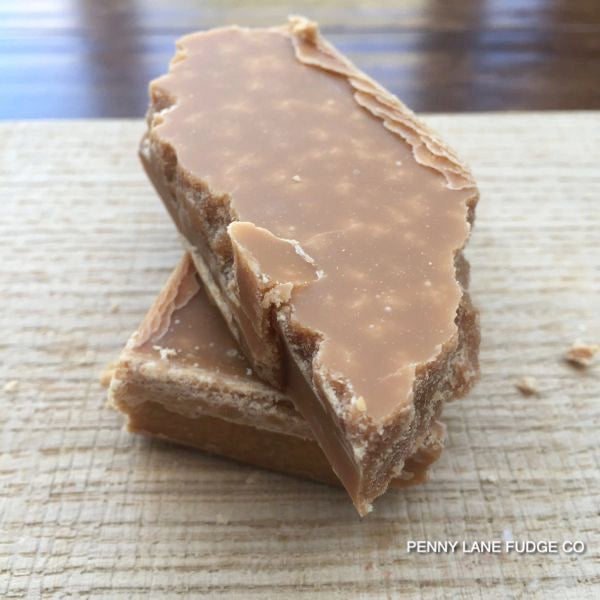 Three pieces of scottish tablet stacked on a textured surface with 'Penny Lane Fudge Co' branding.